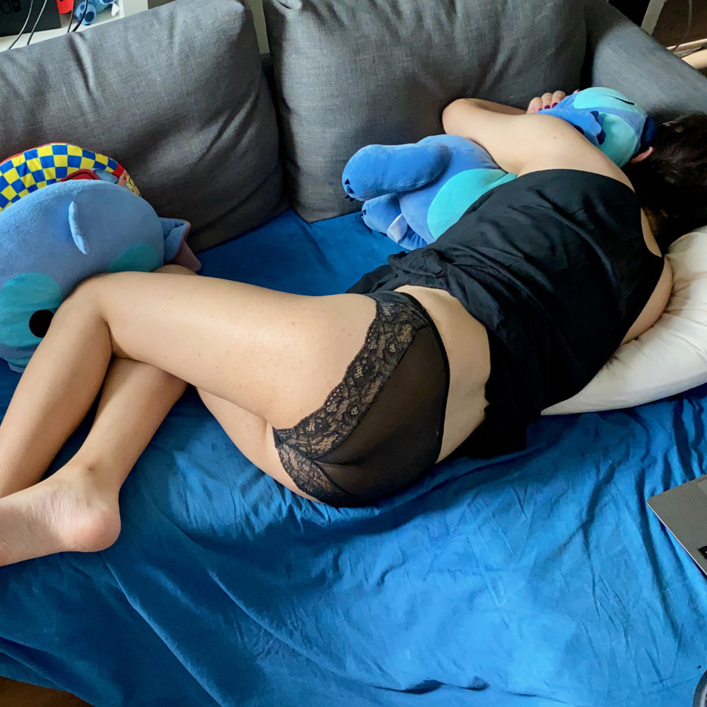 Black beach dress, black lace panties, sleeping on bed facing away from camera, hugging a Stitch plush