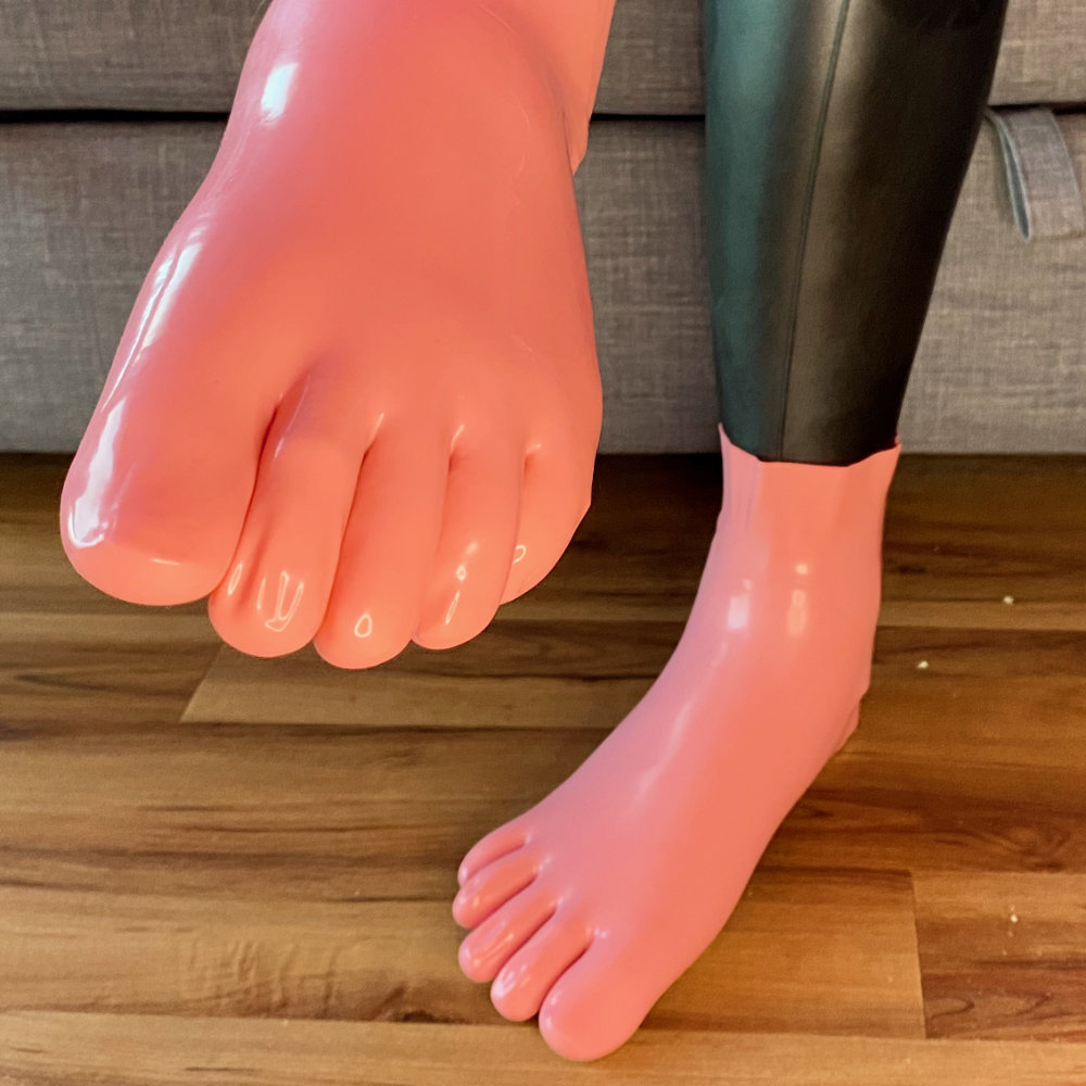 Offering my feet to the camera, clad in pink latex toe socks