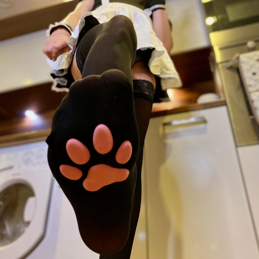 Rina's foot coming down on the camera, wearing paw pad socks and a cat maid costume